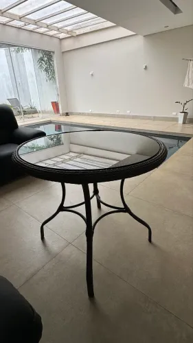 Mesa para 4 lugares, revestida em tramas, com sustentação e tampo de vidro.