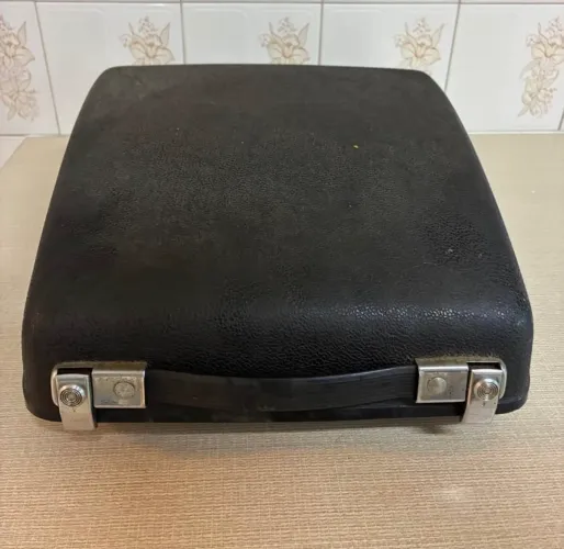 Máquina de datilografia marca Remington com tampa de proteção.