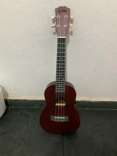 Ukulele spring marrom escuro seminovo, acompanha bolsa de proteção com alça e uma paleta.