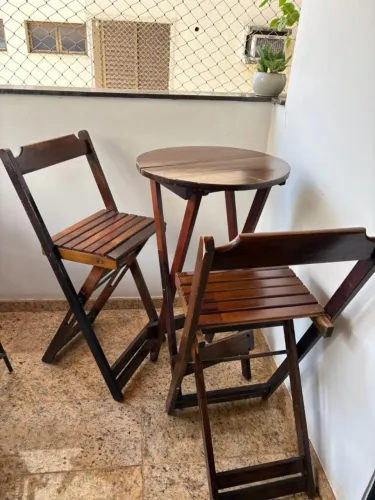 Mesa com 2 cadeiras tipo bar alta de madeira dobrável.
