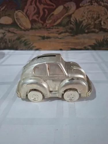cofre decorativo em formato de Fusca feito de metal prateado.