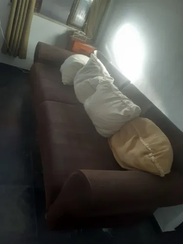 Vendo   sofá   em tecido com almofadas soltas. 