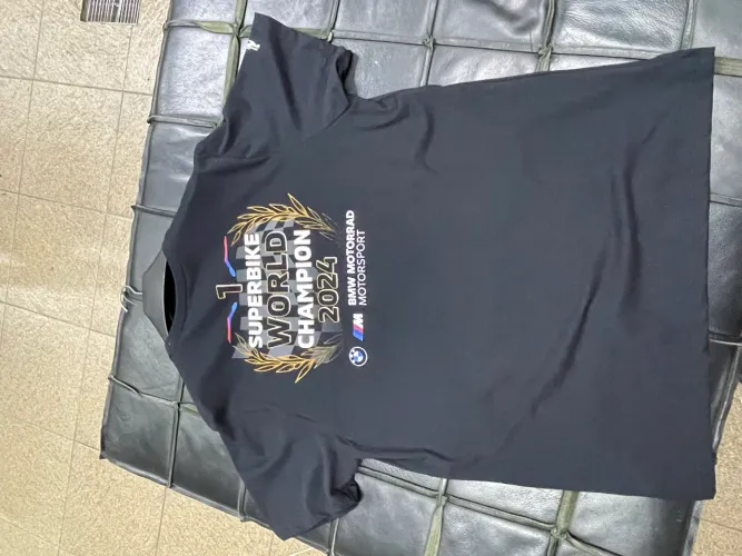 uma camiseta de malha preta com um pequeno gráfico de bandeira quadriculada no peito.