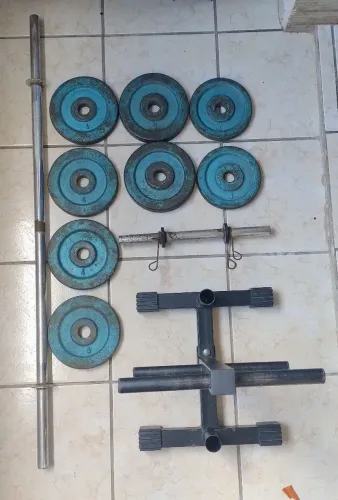 Equipamentos para treinos: anilhas, barras e suporte.