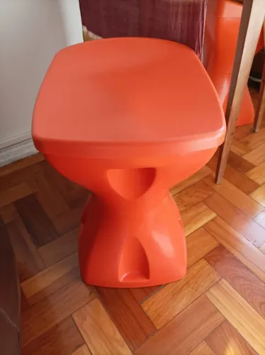Banco laranja em plástico resistente. Abre o assento e vira mesinha petisqueira.