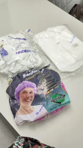 kit de toucas descartaveis na cor rosa e branco e jalecos manga longa descartáveis.