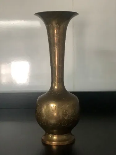 Vaso de metal vintage com padrões gravados.