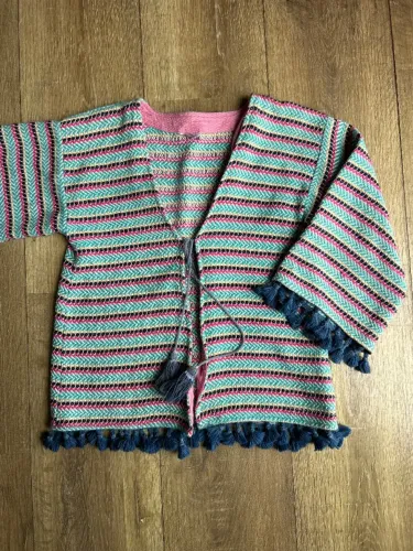 casaqueto infantil da marca renner, estilo boho, tamanho 8-10 anos. possui pompons nas man