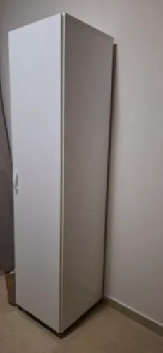 Armário multiuso cor branca1 porta com 3 prateleiras e espaço para escada, com rodinhas.