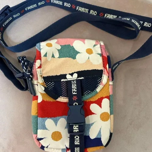 bolsa Farm modelo Fervo com estampa floral colorida e fecho de fivela na frente.