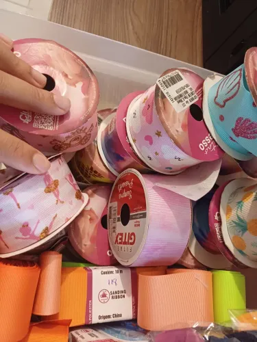 Caixa com várias fitas pra laços. 
