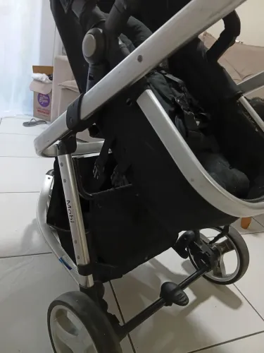 Carrinho de bebê com bebê conforto.