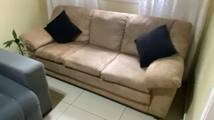 Sofá de 3 lugares marrom com revestimento aveludado.