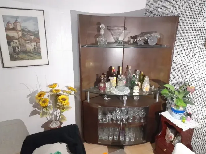 Bar de madeira com prateleiras e armário na parte de baixo com portas de vidro, ler a desc