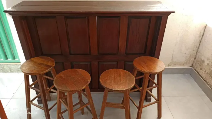 Barzinho de madeira com banquetas.