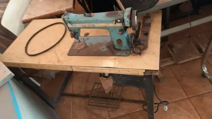 Maquina de costura reta marca Singer com mesa e motor funcionando