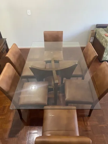 Mesa de jantar tampo de vidro com seis cadeiras.