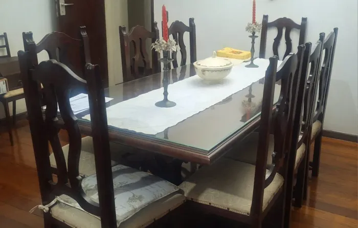 Mesa de madeira com 08 lugares toda trabalhada. Estofados das cadeiras a reformar