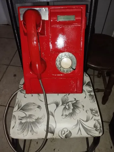 Telefone antigo orelhão vermelho de disco.