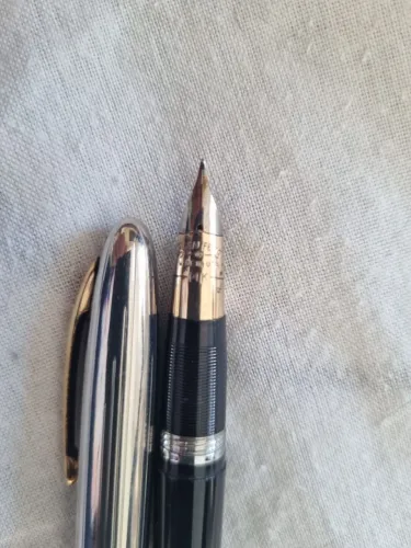 Caneta sheaffer na cor preta e prata.
