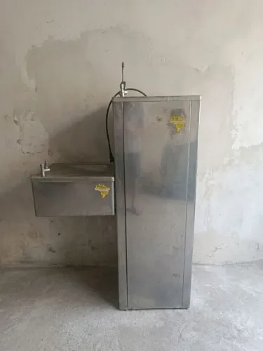 Bebedouro industrial em inox com acessório acessível.