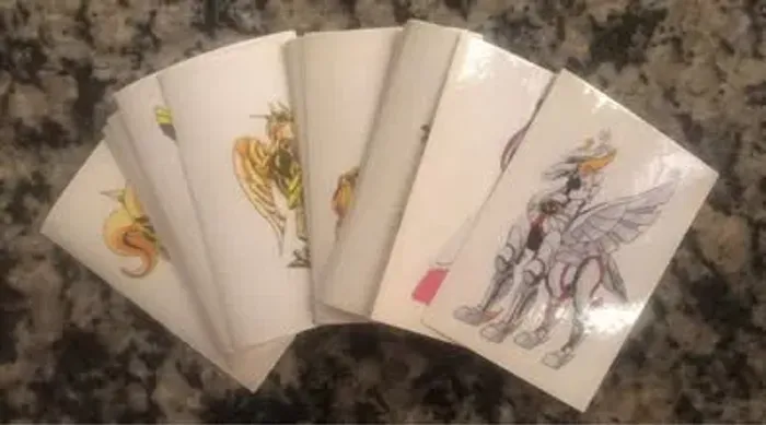 Lote com 10 Figurinhas do Álbum Ilustrado Os Cavaleiros do Zodíaco (2017)
