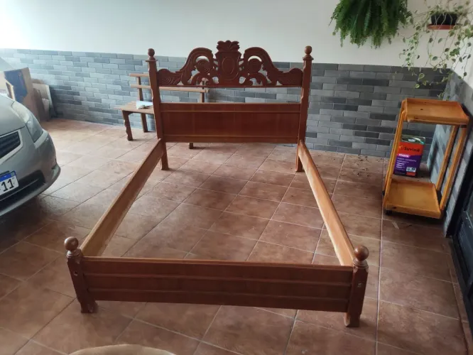Cama de madeira com cabeceira entalhada