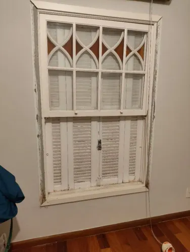 Janela de madeira branca com venezianas