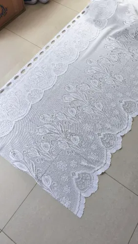 Cortina nova, de renda branca, com desenhos de tulipas.