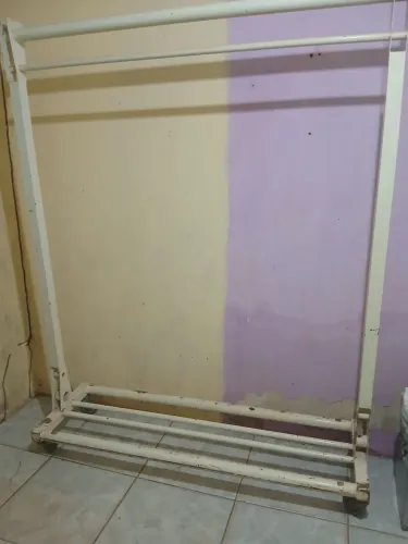 Vendo uma arara e um cesto para roupas.