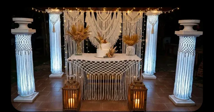 Cenário com colunas iluminadas e macramê