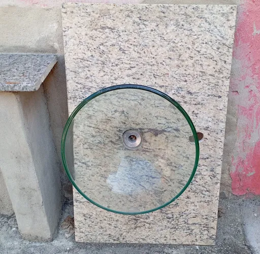 Bancada de mármore com cuba de vidro e aço.