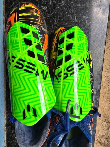 Caneleira Adidas Messi 10 Lesto na cor verde neon.