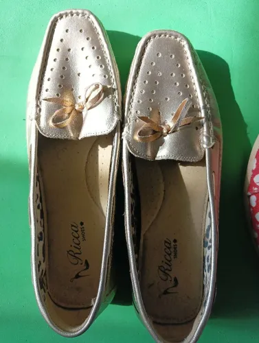 Sapato dourado e sapatilha vermelha