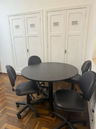 Mesa redonda com quatro cadeiras giratórias de escritório