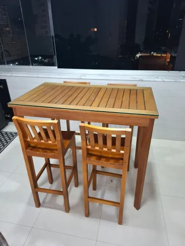 Mesa alta de bar com cadeiras e tampo de vidro
