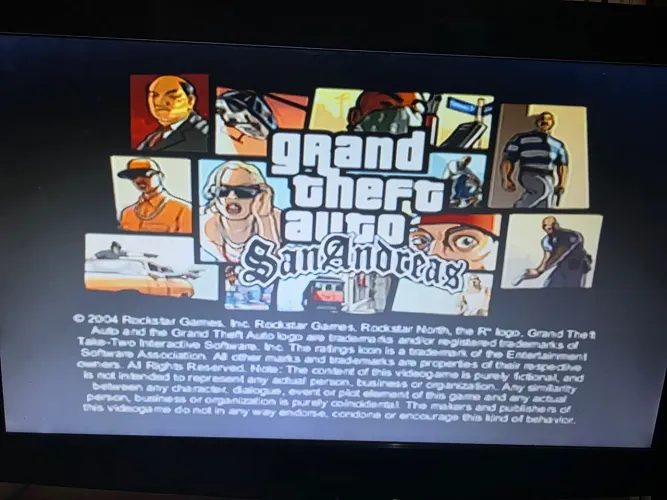 PlayStation 2 com um controle e vários jogos