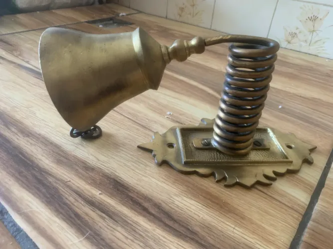 sino de parede artesanal feito de metal dourado