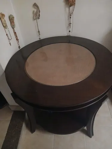 Mesa de centro redonda de madeira escura com tampo de vidro