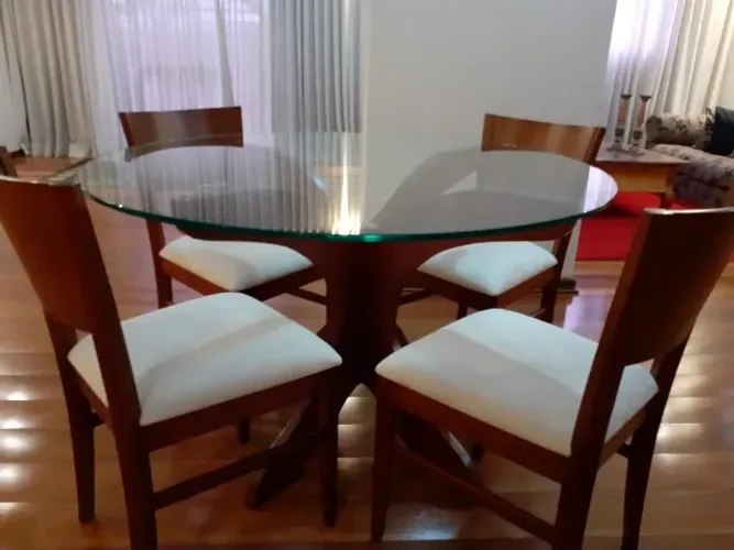 Conjunto de mesa de jantar redonda com quatro cadeiras. Base de madeira e tampo de vidro
