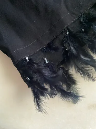 Saia preta com detalhe de penas