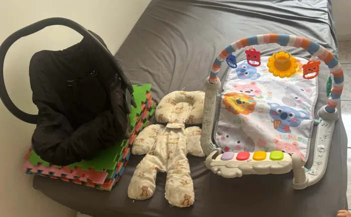 Bebê conforto, redutor, tatame e brinquedo de bebê. 