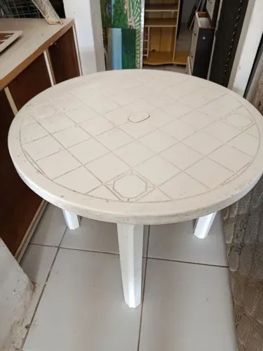 Veja plástica redondo com quatro cadeiras uma está quebrada