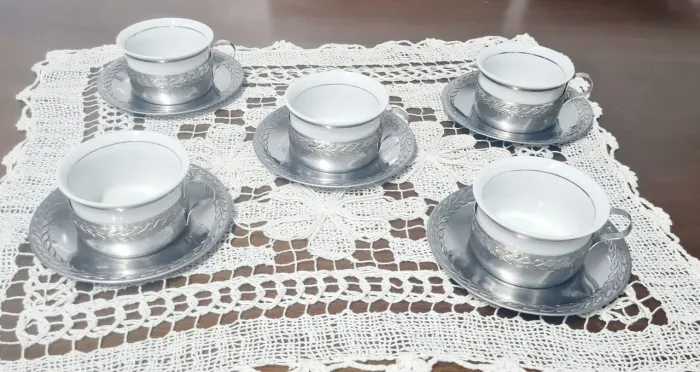 Antigo jogo de xícaras de chá em porcelana Vera Cruz com pires em metal