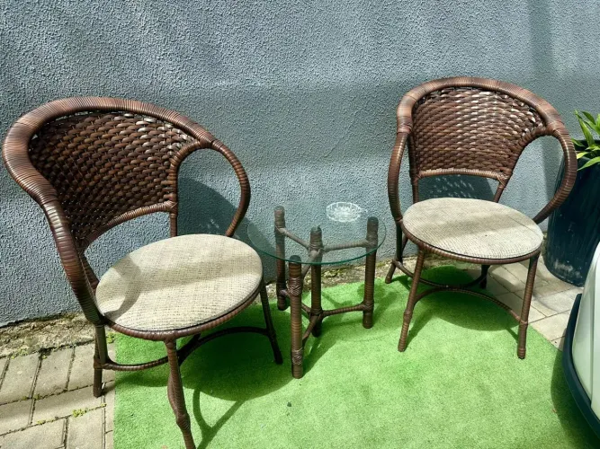 Jogo de duas cadeiras e mesa de vidro.