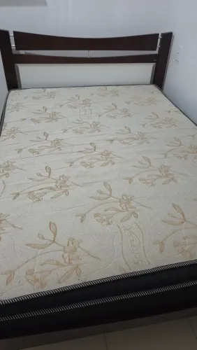 Cama de madeira com colchão de mola ensacada.