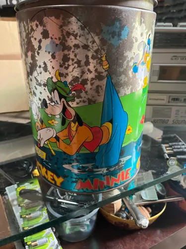 lata de biscoitos antigo com ilustrações de personagens clássicos da Disney.