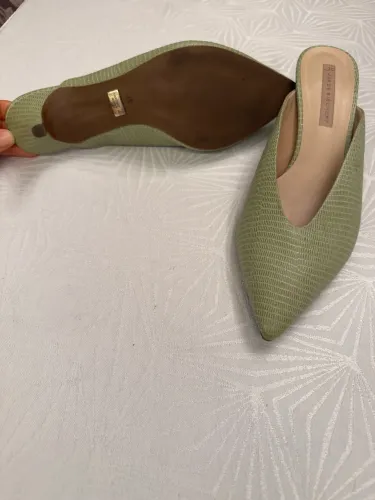 Mule verde-claro com textura de pele de réptil e bico fino da marca Schutz.