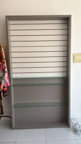 Expositor de parede para loja com painel canaletado e prateleiras de vidro