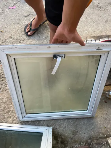 janela basculante de alumínio branco com vidro transparente.